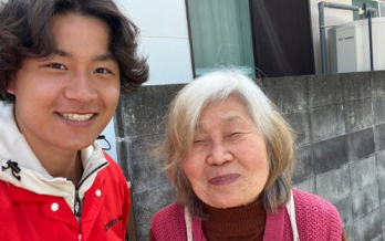 赤い制服を着た男性スタッフが高齢女性と一緒にセルフィーで撮影した写真